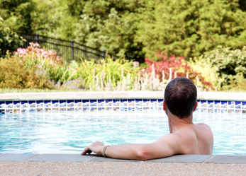 Man sitting in his backyard pool enjoying himself
